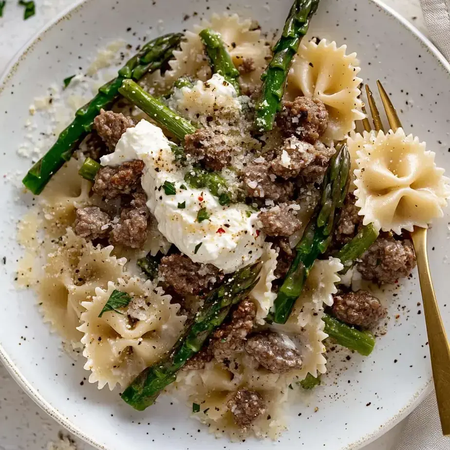 Ein Teller Pasta mit Fleisch und Käse obendrauf.