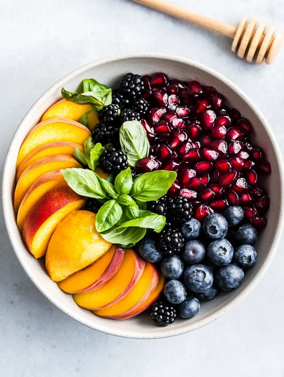Obstschale mit Blaubeeren, Himbeeren, Pfirsichen und Brombeeren.