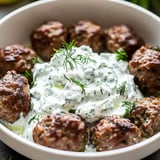 Eine Schale mit Buletten und einem Klecks Sauerrahm obendrauf.