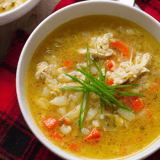 Schüssel mit Suppe und frischem Grün oben drauf.