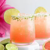 Zwei Gläser pinker Drink mit Limetten.