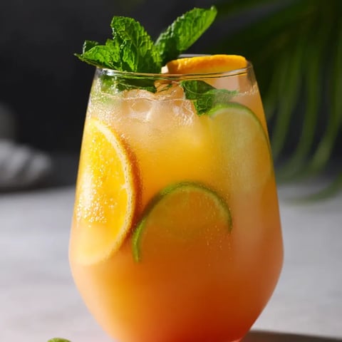 Ein Glas Orangensaft und ein Stück Zitrone.